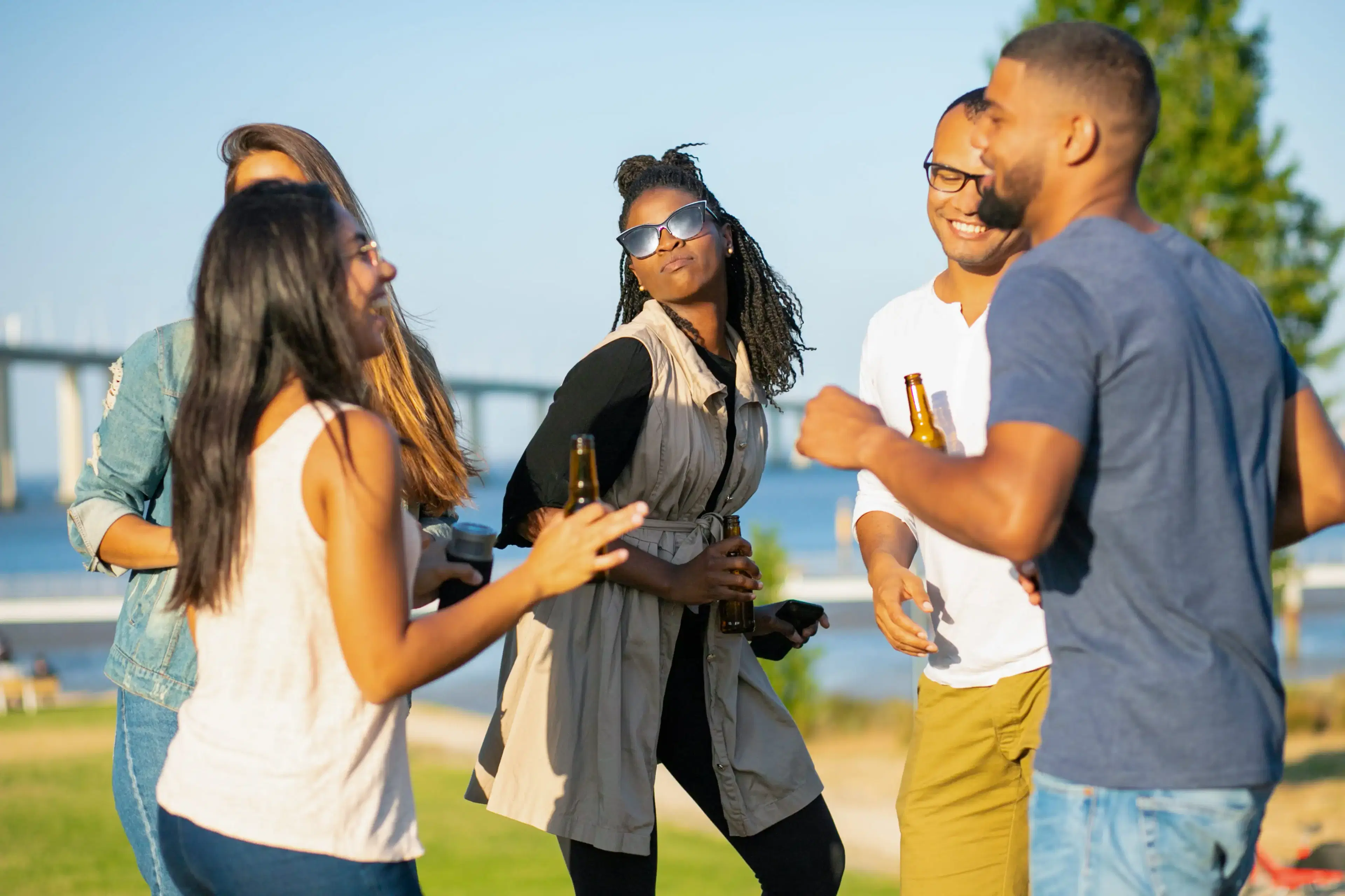 /images/happy-people-dancing-in-the-park-with-beer.webp